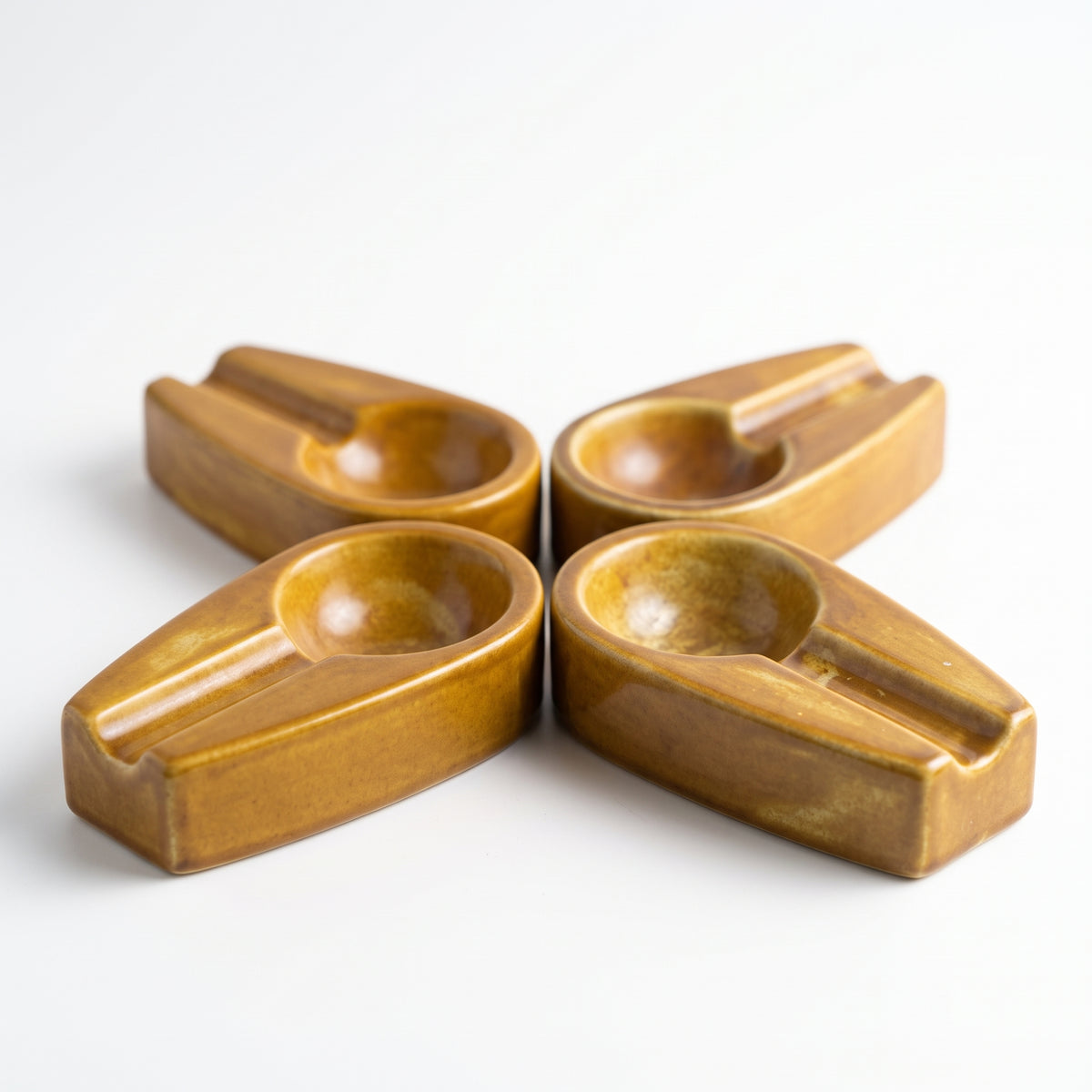 An attractive set of four interlocking ceramic cigar ashtrays, displaying both the yellow and teal color options