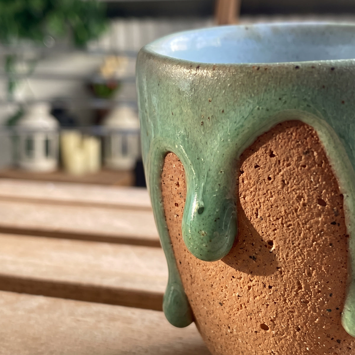 Macro close-up shot showing tactile dripping olive glaze and textured terracotta clay body of the Olive Sip cup.