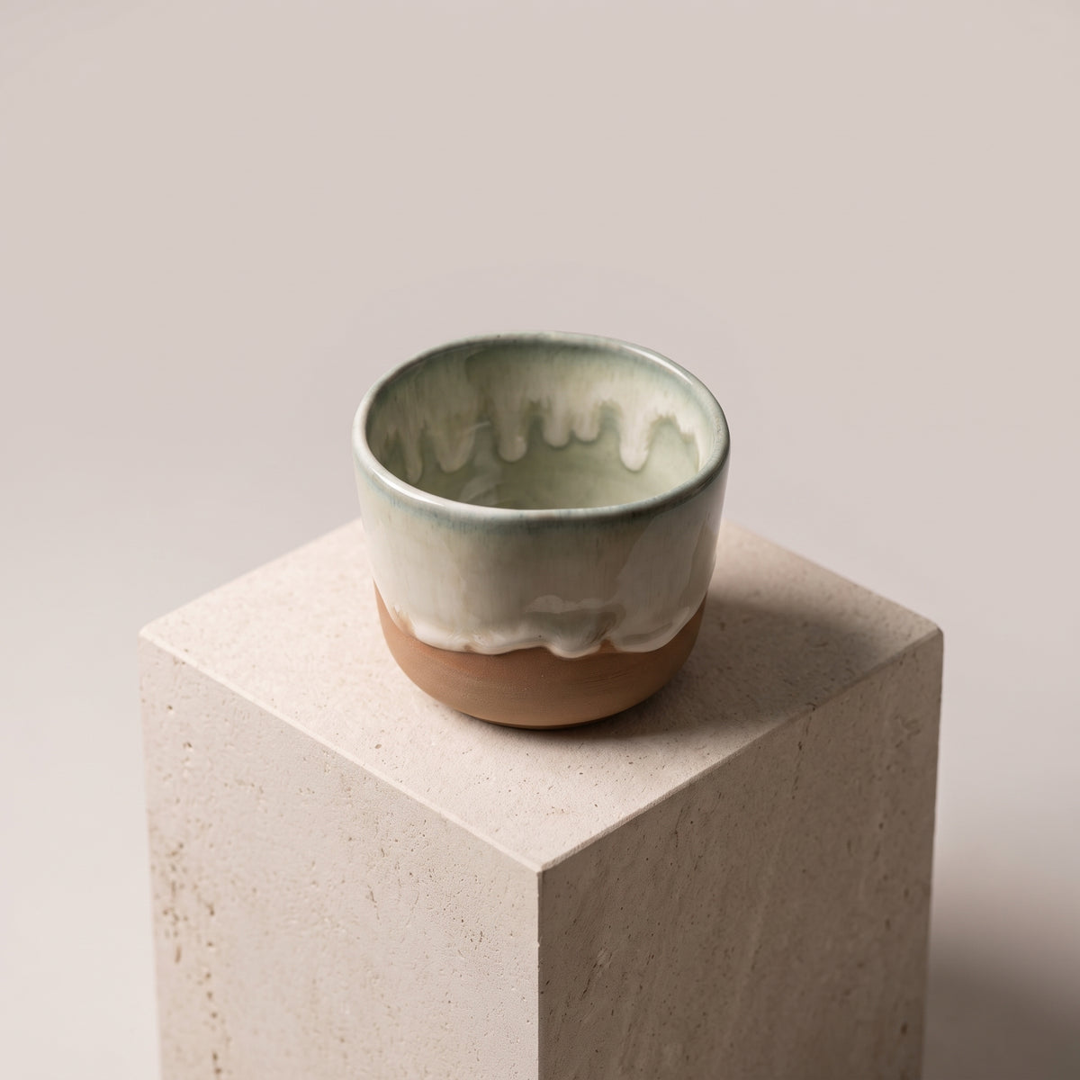 LyLceramics Stone Shot ceramic tumbler resting on a minimal sandstone display cube.